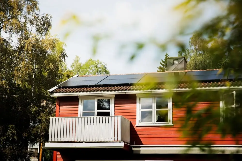 rødt hus med solcellepaneler på taket